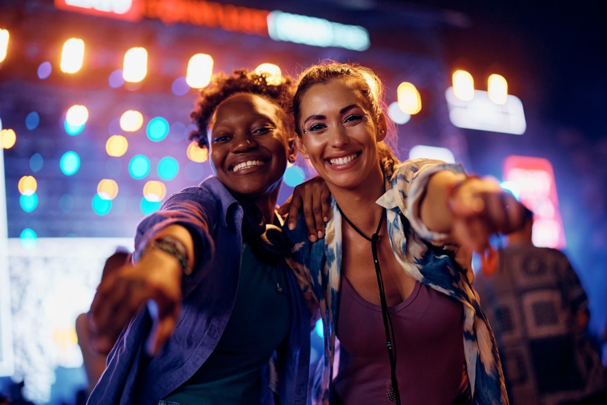 Two friends at a music festival at night